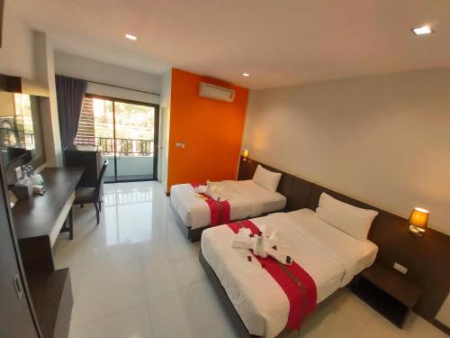 a hotel room with two beds and a desk at The Siri Place in Udon Thani