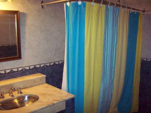 baño con lavabo y cortina de ducha en CABAÑAS JACARANDA en Merlo