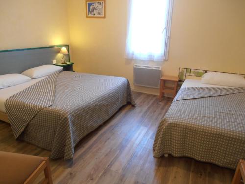 Cette chambre comprend 2 lits et une fenêtre. dans l'établissement Hôtel Restaurant Alios, à Bas-Mauco