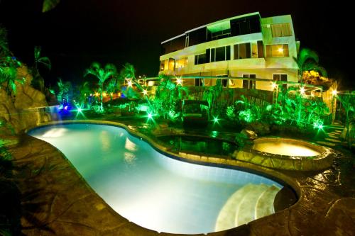 a swimming pool in front of a building at night at ME Hotel & Villas - Montañita Estates in Montañita