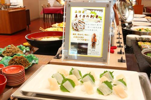 a table topped with plates of food and a sign at Hotel Hokke Club Hakodate in Hakodate