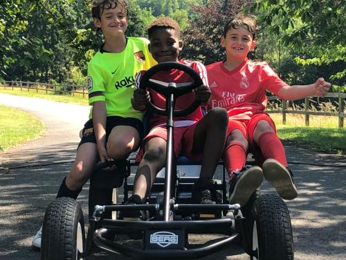three young boys sitting on a four wheeler vehicle at Domaine De L'Ardoisiere in Alle