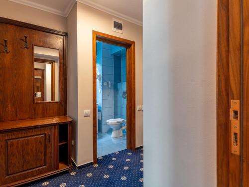 uma casa de banho com um WC e um espelho. em Hotel Ski&Sky em Predeal