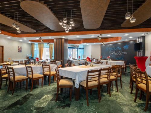 a dining room with tables and chairs and a chalkboard at Hotel Ski&Sky in Predeal