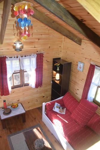 una sala de estar con una cama en una cabaña de madera en Cabaña Picaflores en Barra de Valizas
