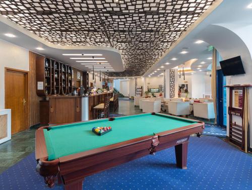a pool table in the middle of a room at Hotel Ski&Sky in Predeal