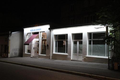 a lit up store front at night at Hotel De L'Europe in Toul