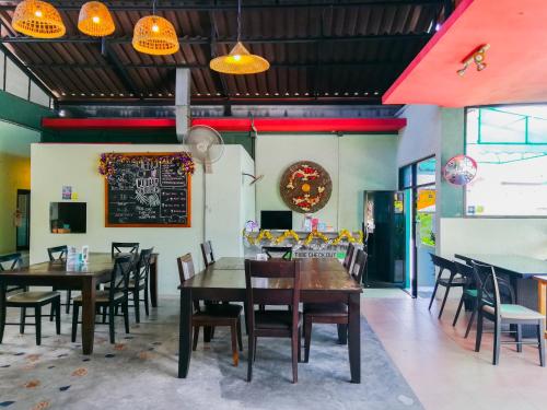 a dining room with tables and chairs and a chalkboard at 2 Home in Chalong