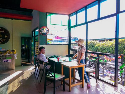 two people sitting at a table in a restaurant at 2 Home in Chalong 