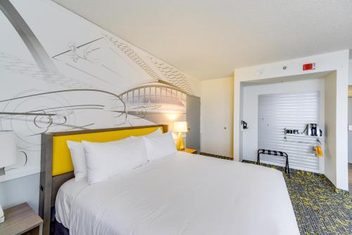 a bedroom with a white bed and a painting on the wall at Saint Louis Airport Hotel in Saint Louis