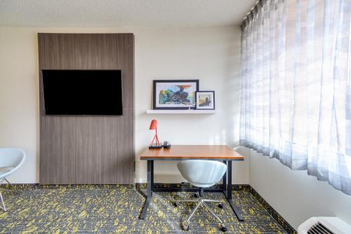 a hotel room with a desk and a television at Saint Louis Airport Hotel in Saint Louis