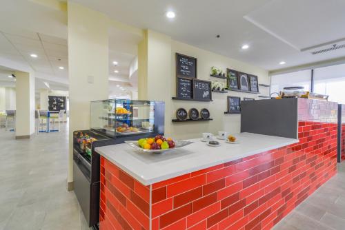 a kitchen with a bowl of fruit on a counter at Saint Louis Airport Hotel in Saint Louis