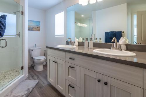 a bathroom with two sinks and a toilet and a mirror at Roadrunner's Roost in Twentynine Palms