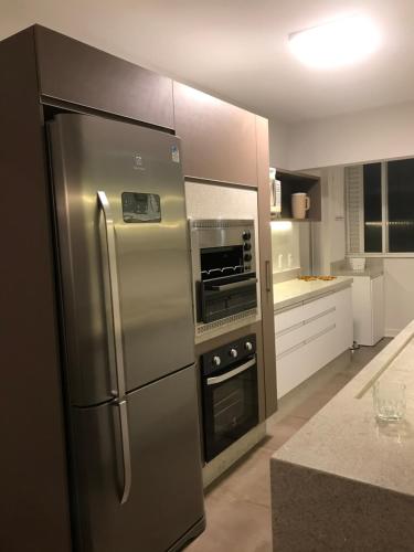 een keuken met een roestvrijstalen koelkast en een oven bij Apartamento Frente Mar in Balneário Camboriú