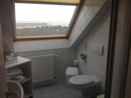 a bathroom with a toilet and a window at Hotel Mocca-Stuben in Helgoland