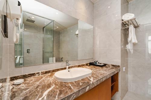 bagno con lavandino e specchio di Fu Hua International Hotel Dunhuang a Dunhuang