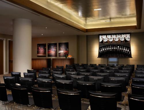 einen Konferenzraum mit schwarzen Stühlen und einer Bühne in der Unterkunft Ink 48 Hotel in New York