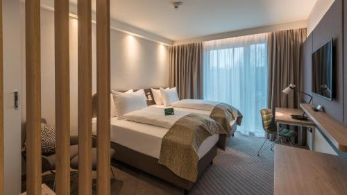 a hotel room with a bed and a desk and a television at Holiday Inn - Hamburg - Berliner Tor by IHG in Hamburg
