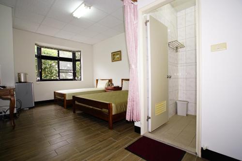- une chambre avec un lit et une douche dans l'établissement Fumei Bluebird Homestay, à Nanzhuang