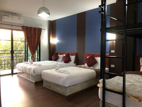 a bedroom with two beds and a bunk bed at Baan Rai Phufah Resort Chiangrai in Ban Pa Ruak