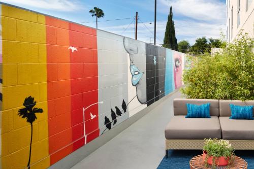 a colorful mural on a wall next to a couch at Kimpton Hotel Wilshire, an IHG Hotel in Los Angeles