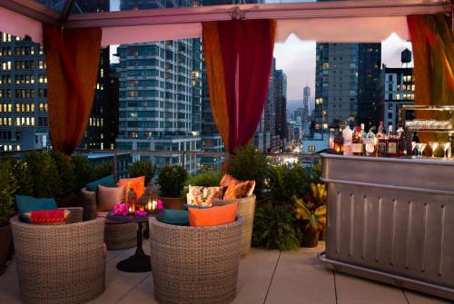 eine Bar auf der Dachterrasse mit Stadtblick in der Unterkunft Kimpton Hotel Eventi, an IHG Hotel in New York
