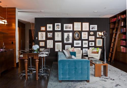 a living room with a blue couch and a wall of pictures at Kimpton Hotel Eventi, an IHG Hotel in New York