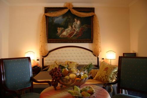 a living room with a table with a bowl of fruit at Grand Hotel Palace in Marsala