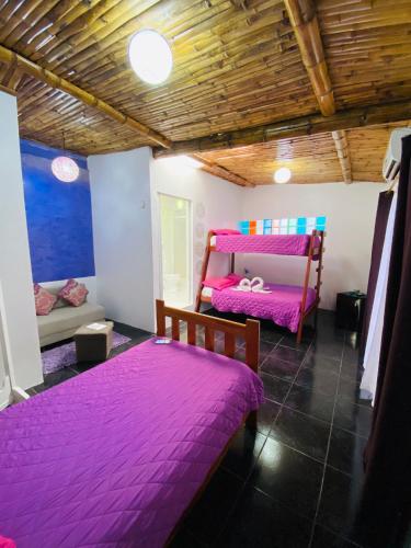 two beds in a room with purple sheets at Zurisadai in Puerto Ayora