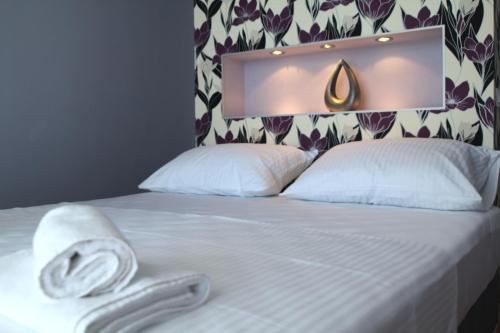 a bed with white sheets and a towel on it at Villa Lavanda Deluxe in Rogoznica