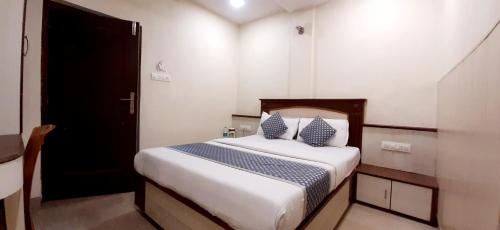 a small bedroom with a bed with two pillows at Hotel Aroma- Dadar in Mumbai
