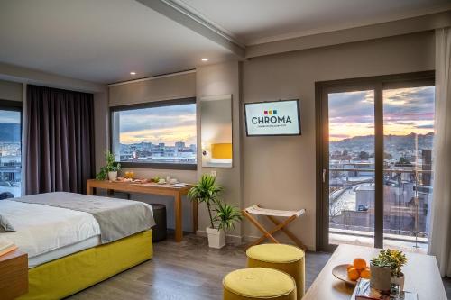a bedroom with a bed and a desk and windows at CHROMA FASHION ROOMS & APARTMENTS in Athens