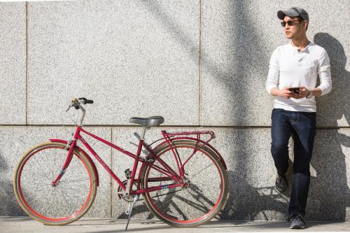 a man is standing next to a red bike at Kimpton Schofield Hotel by IHG in Cleveland