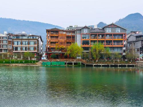 um grupo de edifícios ao lado de uma massa de água em Lee's Boutique Resort em Zhangjiajie