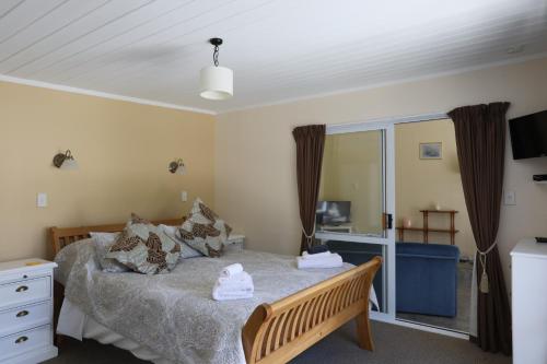 a small bedroom with a bed and a window at Central Cottages in Kerikeri