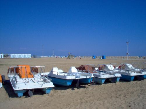 a group of boats sitting on the beach at Adriella apartments in Bibione