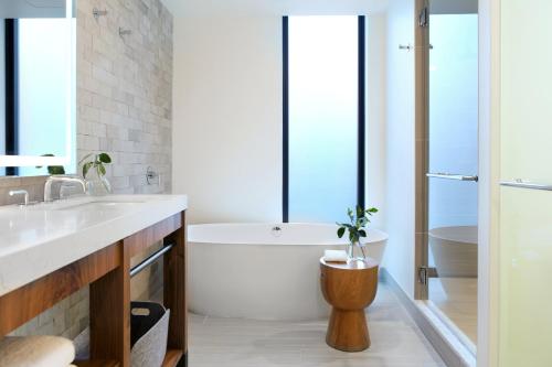 a bathroom with a tub, toilet and sink at Kimpton Hotel Born, an IHG Hotel in Denver