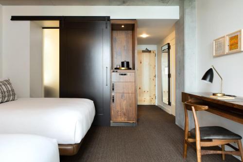 a hotel room with a bed and a desk and a desk at Limelight Hotel Denver in Denver