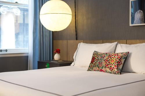 a bedroom with a white bed with a pillow and a lamp at Kimpton Gray Hotel Chicago by IHG in Chicago