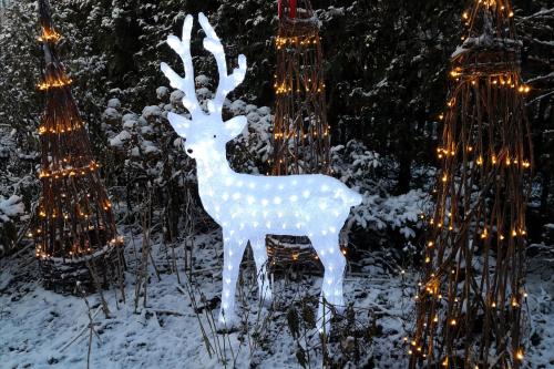 a statue of a deer in the snow with lights at Lovely Mint Garden Studio in Vantaa