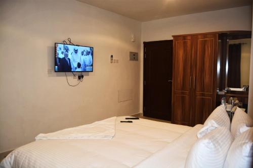 a bedroom with a bed with a television on the wall at BAITI Furnished Apartments in Salalah