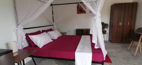 1 dormitorio con 1 cama grande con dosel en Lonos Circle Private Garden en Romblon