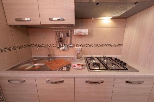 a kitchen with a sink and a stove at Arcobaleno Apartment in Fondi