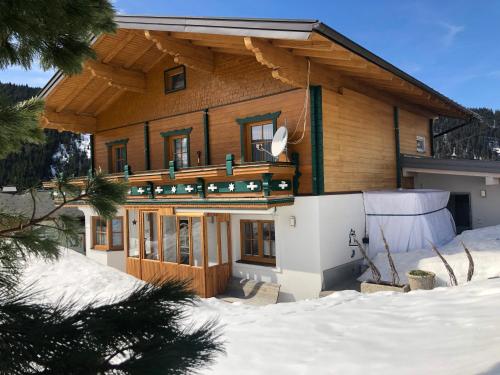 a log house in the snow with snow at Haus Waldrast in Filzmoos