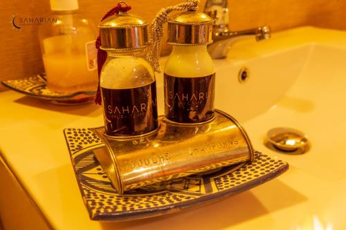 dwie butelki mydła na zlewie w łazience w obiekcie Sahara Merzouga Luxury Camp w mieście Merzouga