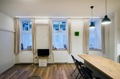 a room with a desk with chairs and windows at Pacman Apartment in Budapest