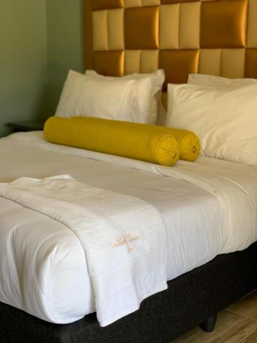 a yellow blanket laying on top of a white bed at La Fiato Luxury Lodge in Dalmada AH