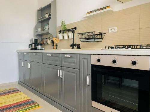 a kitchen with gray cabinets and a stove top oven at Condmari Residential Apartament in Braşov