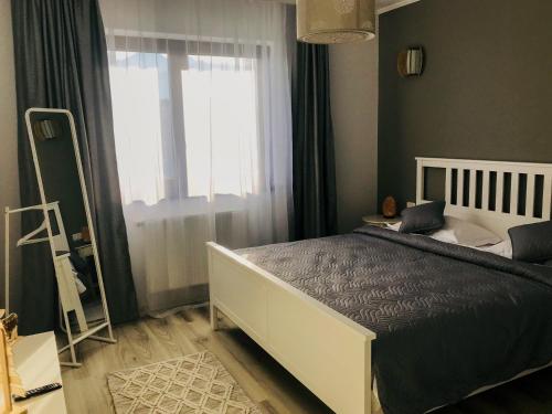 a bedroom with a large bed and a window at Condmari Residential Apartament in Braşov