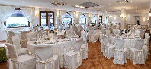 uma sala cheia de mesas e cadeiras com toalha de mesa branca em Hotel Villa Degli Angeli em Castel Gandolfo